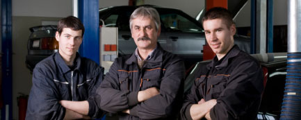 3 mechanics in auto repair shop