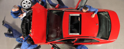 mechanics working on red sports car